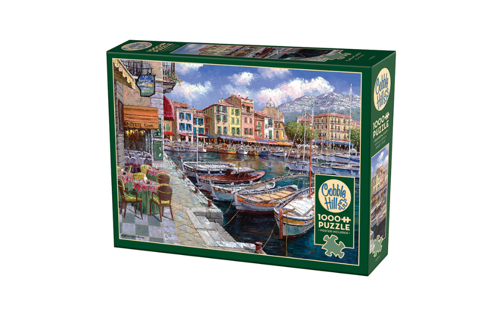 Cobble Hill 1000 Piece Cafe in Cassis Jigsaw Puzzle featuring a picturesque harbour scene