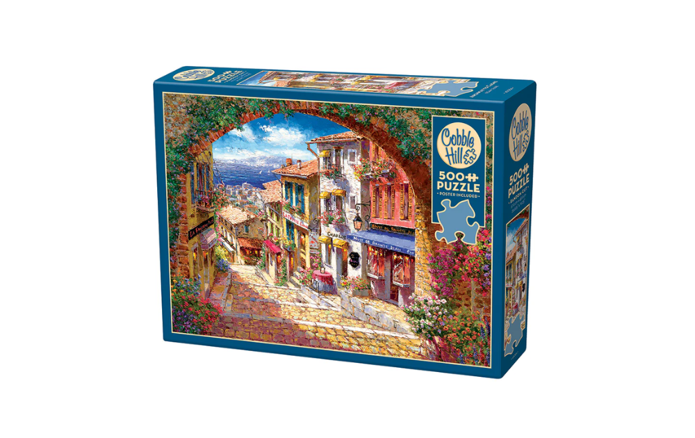 Cobble Hill 500 Piece Archway to Cagne Jigsaw Puzzle featuring a charming European street scene