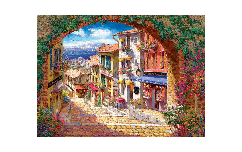 Cobble Hill 500 Piece Archway to Cagne Jigsaw Puzzle featuring a picturesque village scene