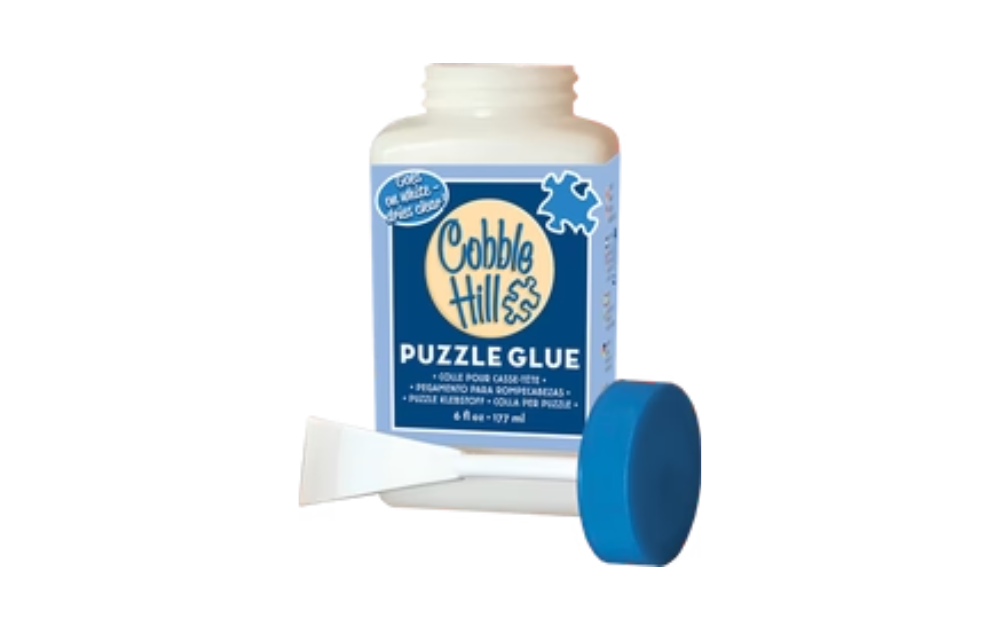 Cobble Hill puzzle glue bottle with applicator and blue cap for sealing completed jigsaw puzzles
