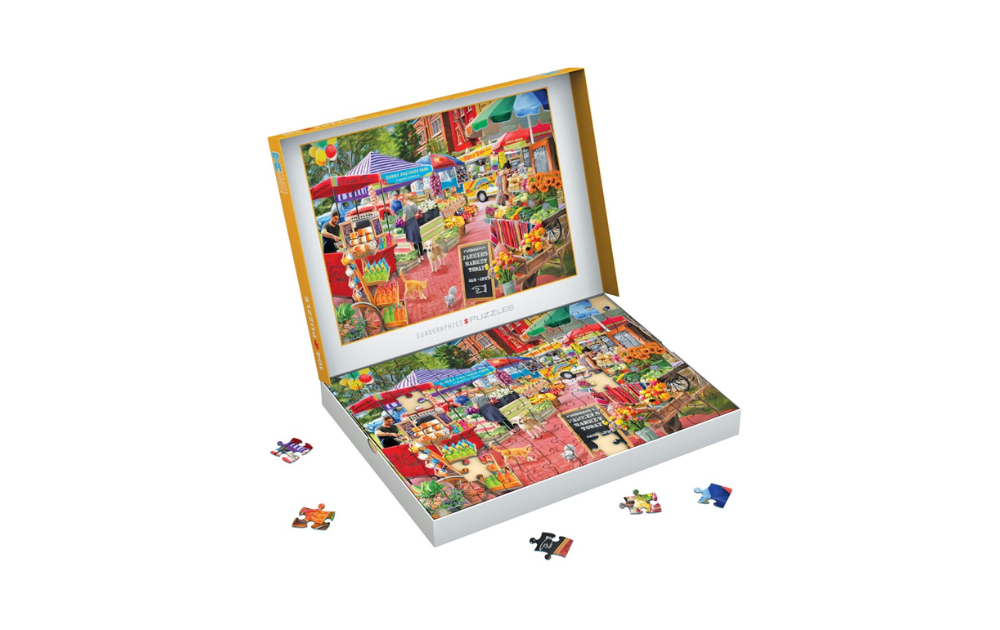 Eurographics jigsaw showing A Day at the Farmers Market puzzle open box with colourful completed scene and scattered pieces