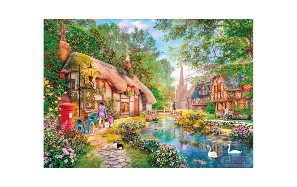 Cottageway Lane 500 piece puzzle featuring a charming village scene with a bridge and flowers