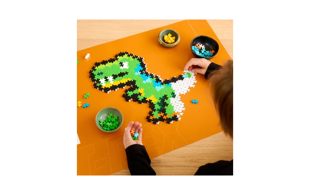 Plus Plus dinosaur jigsaw puzzle being assembled on orange mat with colorful plus plus pieces