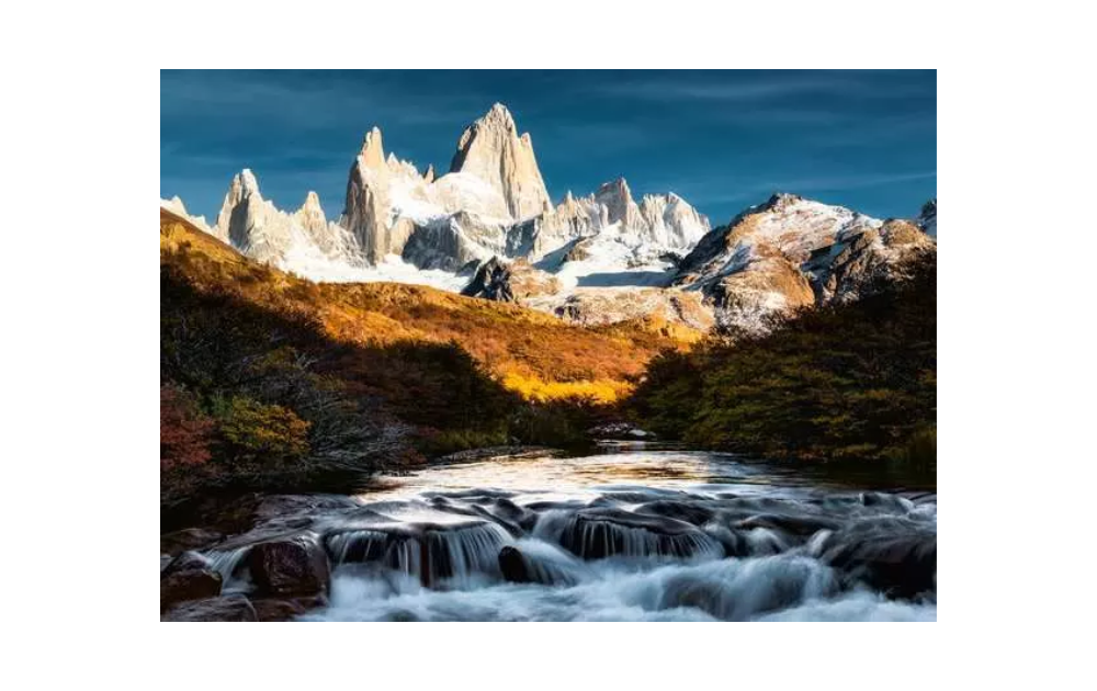 Ravensburger Patagonia mountain jigsaw puzzle featuring snowy peaks and flowing river landscape