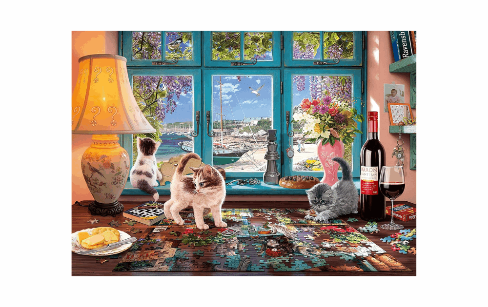 The Puzzler's Desk jigsaw puzzle featuring playful cats and a beautiful coastal view