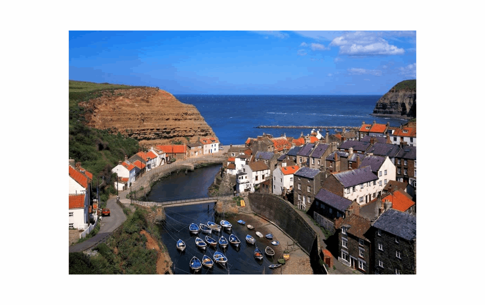 Beautiful coastal scene of Staithes 1000 piece jigsaw featuring boats and colorful houses